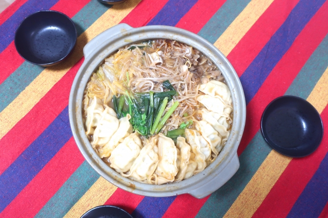白菜や青菜、餃子が入った土鍋の鍋料理（鍋の残りアレンジのイメージ）