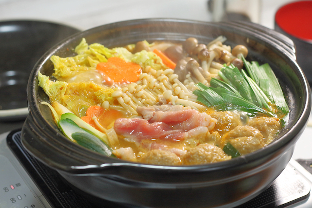 豚肉やきのこ、にんじんが入った土鍋の鍋（次の日のお弁当アレンジのイメージ）