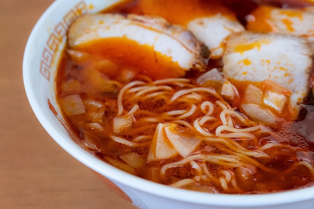 赤いピリ辛スープに麺を入れたラーメン（スンドゥブの具材に麺を入れるイメージ）