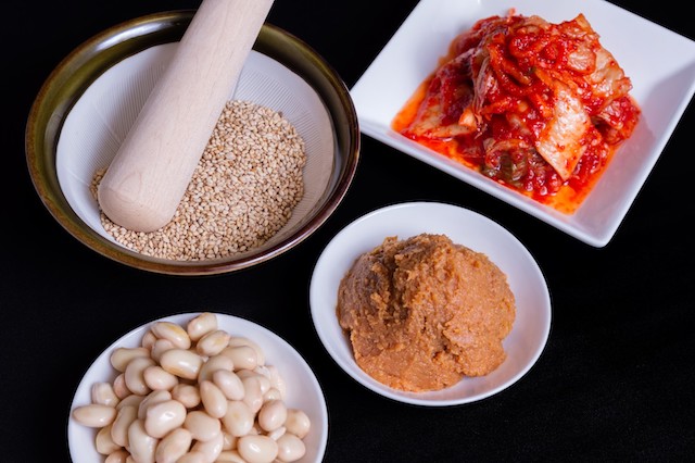 キムチ・味噌・ごま・大豆を並べた韓国料理の食材